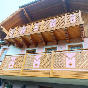 uma varanda de madeira num edifício com telhado de madeira em Ferienhaus Gstoderblick em Seebach
