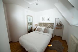 une chambre avec un grand lit blanc dans un grenier dans l'établissement Unique 2 Bedroom Cottage in Fittie (Footdee), à Aberdeen