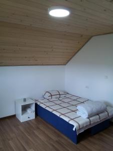 a bed in a room with a wooden ceiling at Apartman Teodora Uvac in Nova Varoš