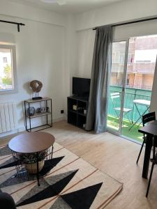 een woonkamer met een tafel en een groot raam bij Apartamentos Garnacha 2 totalmente reformado in Zaragoza