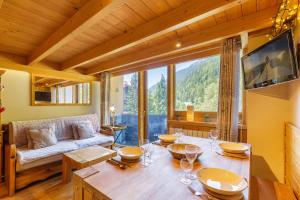 een woonkamer met een tafel en een bank bij Résidence Grand Roc - Campanules 202 - Happy Rentals in Chamonix-Mont-Blanc