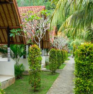 een loopbrug voor een gebouw met planten bij Penida Bay Village in Nusa Penida