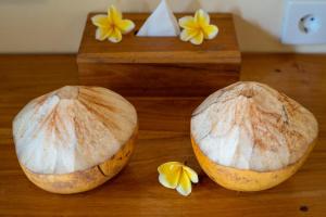 two mushrooms on a wooden table with yellow flowers at Penida Bay Village in Nusa Penida