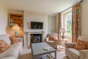 a living room with two couches and a fireplace at Bluebell Cottage in Chippenham