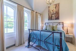 - une chambre avec un lit et 2 fenêtres dans l'établissement Bluebell Cottage, à Chippenham