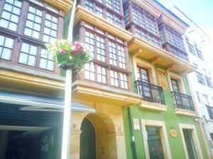 a building with a flower pot on the side of it at ORTEGA SUITE, dúplex en el centro de Luanco in Luanco