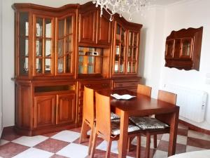 a dining room with a wooden hutch and a table at ORTEGA SUITE, dúplex en el centro de Luanco in Luanco