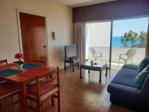 a living room with a blue couch and a table at Seascape 501 in Larnaca