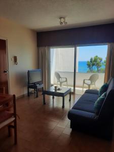 a living room with a couch and a view of the ocean at Seascape 501 in Larnaca
