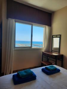 a bedroom with a bed with a window and a desk at Seascape 501 in Larnaca +28 photos
