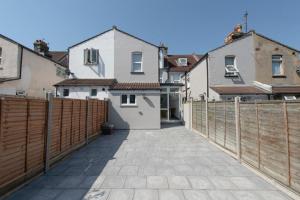 a fence in front of some white buildings at Stunning 6 Bed House in Medway with 10 beds 4 bathrooms sleeps 15 in Gillingham