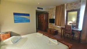 a bedroom with a bed and a desk and a mirror at Simosmare Resort in Elafonisos