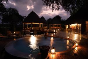 a swimming pool at night with lights around it at Hoyo Hoyo Safari Lodge in Mluwati Concession 