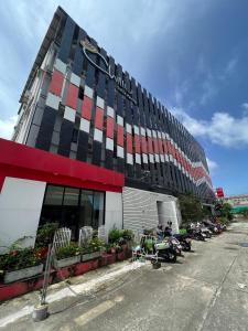 un gran edificio con coches estacionados frente a él en The Chilli Patong Beach Hotel - Near to the Beach -Completed Fully renovate 2023, en Patong Beach