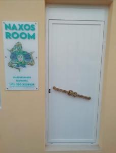 una puerta blanca con un cartel en la pared en Naxos Room, en Giardini Naxos