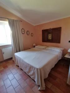 1 dormitorio con 1 cama blanca grande en una habitación en B&B L'Uliveto, en Montebuono