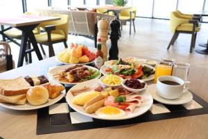 a table topped with plates of breakfast foods and coffee at The Quart Ruamrudee by UHG in Bangkok