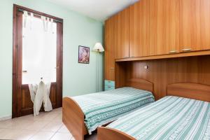 1 dormitorio con cama y ventana en Case Vacanza Aiosardegna, en Pula