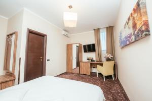 Cette chambre comprend un lit et un bureau. dans l'établissement C Guest House, à Drobeta-Turnu Severin
