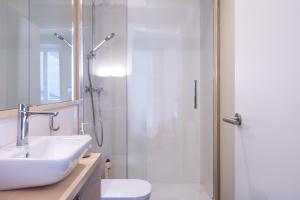 un bagno bianco con doccia e lavandino di HERITAGE APARTMENTS CERDANYA al carrer Major i parking a Puigcerdà Altre 42 foto