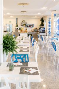 a row of tables and white chairs in a restaurant at Hotel Majorca in Gabicce Mare