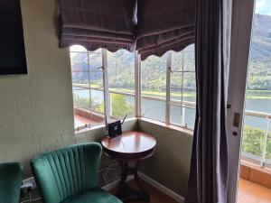 a room with a table and chairs and a large window at Letamong in Hartbeespoort