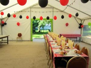 een set tafels in een tent met rode en zwarte ballonnen bij Maison de 3 chambres avec jardin amenage et wifi a Coulombs en Valois in Mary-sur-Marne