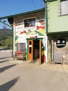 ein Gebäude mit einer Bank davor in der Unterkunft Хостел Васкул in Kvasy