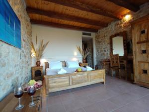 a bedroom with a bed and a table with wine glasses at Simosmare Resort in Elafonisos