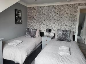 2 camas individuales en un dormitorio con pared en The Admiral's Rest, en Scarborough