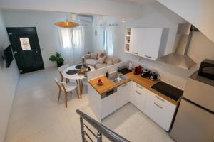 cocina y sala de estar con mesa en Casa Rossa e Verde by All About Paxos en Gaios