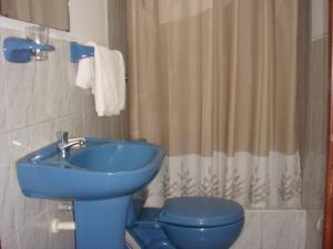 uma casa de banho com um lavatório azul e um WC. em Hotel Begonias em Lambayeque