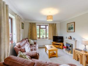 a living room with a couch and a television at The Willows in Church Stretton