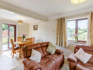 a living room with a leather couch and a table at The Willows in Church Stretton