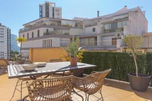 un tavolo e sedie su un balcone con un edificio di Paola Penthouse - Costa CarpeDiem a Calpe