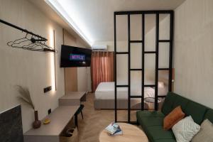 a living room with a green couch and a tv at LEO CENTRALE in Kalamata