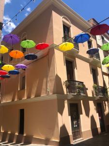 Une bande de parapluies colorés suspendus à un bâtiment dans l'établissement Casa Vacanze - Il Balconcino, à Iglesias