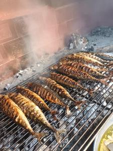 a group of sausages cooking on a grill at Vila Neve 87 Apartman in Veliko Brdo