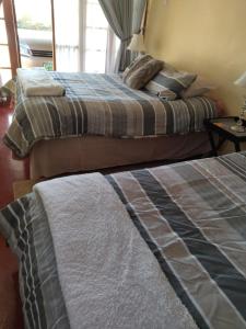 two beds in a hotel room with two beds at Rebanien2 Overnight Accommodation Double and Single bed in De Aar