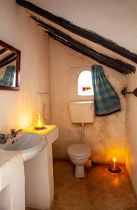 a bathroom with a white toilet and a sink at Jannat House in Lamu
