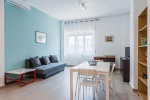 uma sala de estar com um sofá e uma mesa em Rapisardi 188 Apartment by Wonderful Italy em Catânia