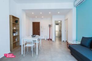 uma sala de estar com uma mesa e cadeiras e um sofá em Rapisardi 188 Apartment by Wonderful Italy em Catânia