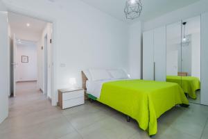 um quarto branco com uma cama verde e um corredor em Rapisardi 188 Apartment by Wonderful Italy em Catânia