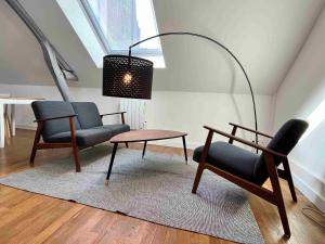 sala de estar con 2 sillas, mesa y lámpara en Hyper centre ville STUDIO, en Angers