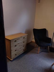 una camera da letto con cassettiera e sedia nera di Ferien-in-ruhiger-Strasse-in-Stadtteil-von-Giessen a Gießen