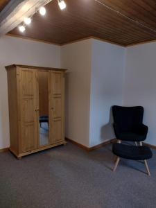 a room with a black chair and a cabinet at Ferien-in-ruhiger-Strasse-in-Stadtteil-von-Giessen in Gießen