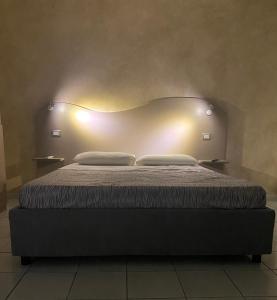 un letto in una stanza con due luci sopra di B&B Akoya Capo Vaticano a Capo Vaticano
