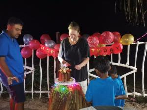 Una donna che taglia una torta di compleanno sopra un tavolo di Helios Beach Resort a Tangalle Altre 37 foto