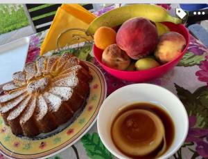 B&B Il Sentiero في San Sperate: طاولة مع صحن من الكعك و صحن من الفاكهة