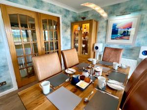 Toradale B&B في Skeabost: غرفة طعام مع طاولة وكراسي خشبية